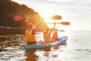 Family Of 3 In Kayak With A Sunset Background