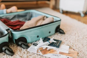 Open Suitcase With A Few Clothes Inside And Travel Paperwork